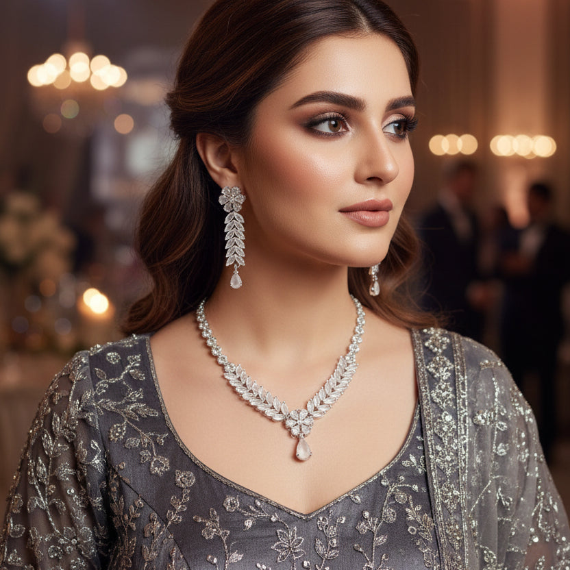 Silver necklace and earrings set on a dark background