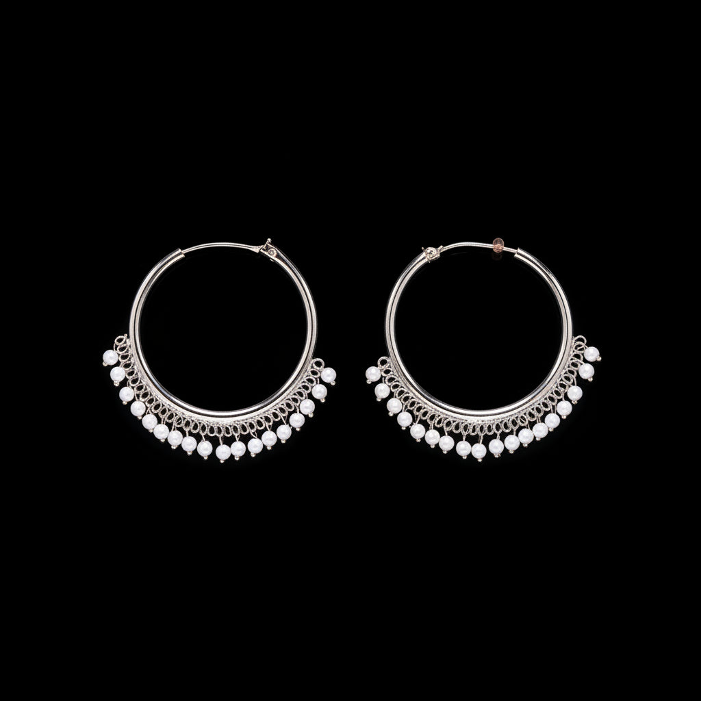 Pair of silver hoop earrings with bead detailing on a brown background