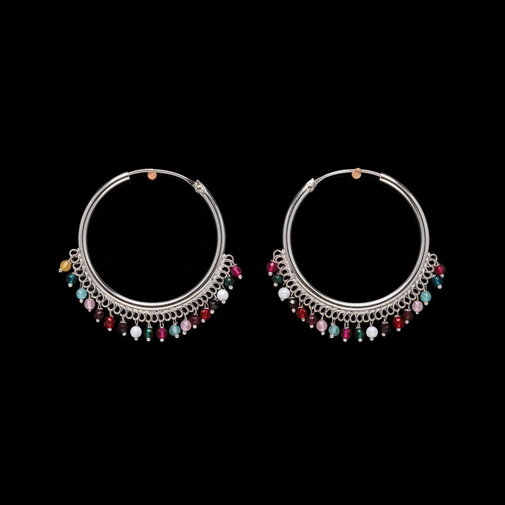 Pair of silver hoop earrings with colorful beads on a brown background