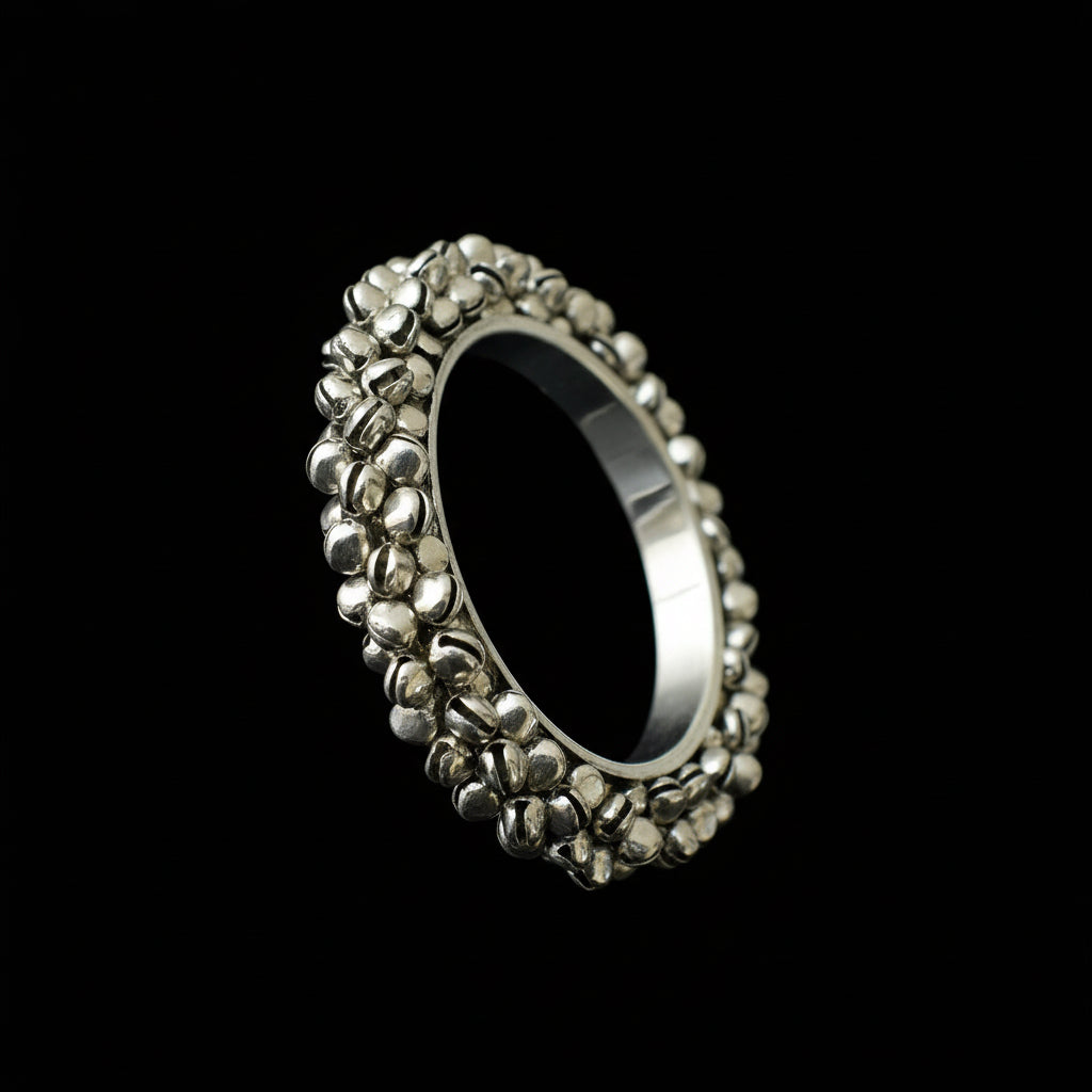 Silver ring with textured band on a dark background