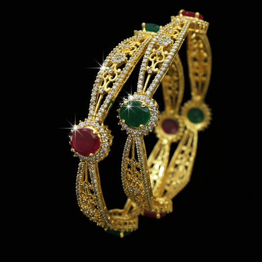 Gold bangles with gemstones on a dark background, featuring the brand 'Saheli'.