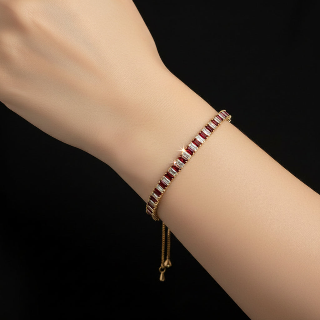 Gold bracelet with red and white stones on a black background