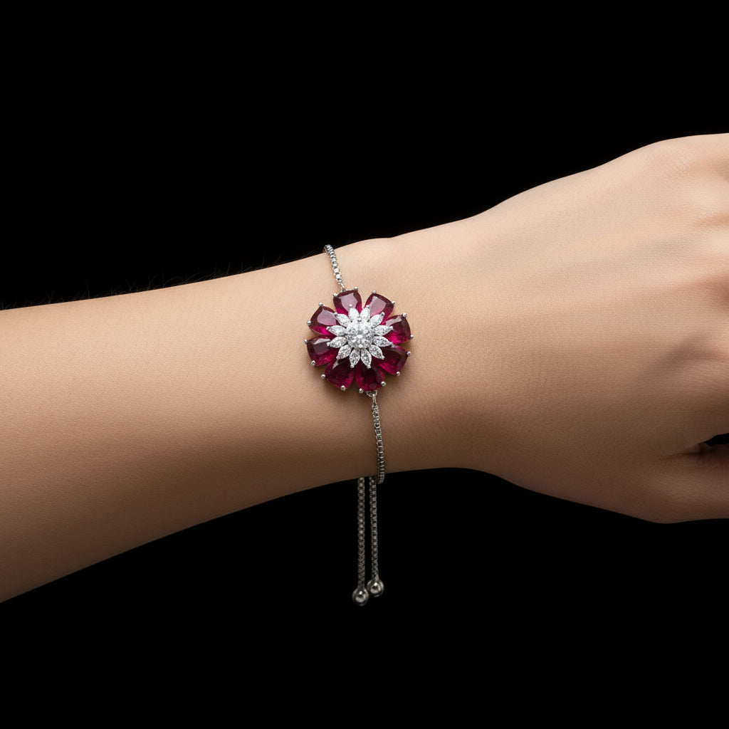 Silver bracelet with red and white gemstones on a gray background, branded 'SAHELLI'.