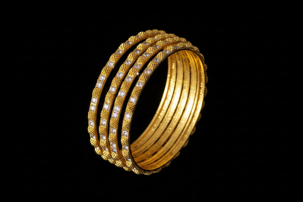 Three gold bangles on a gray stand with 'SAHELI' branding.