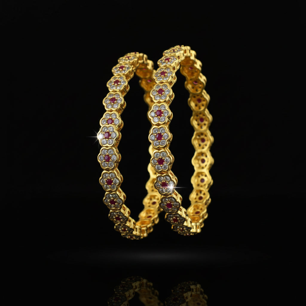 Gold bangles with red stones on a black background, branded 'Saheli'.