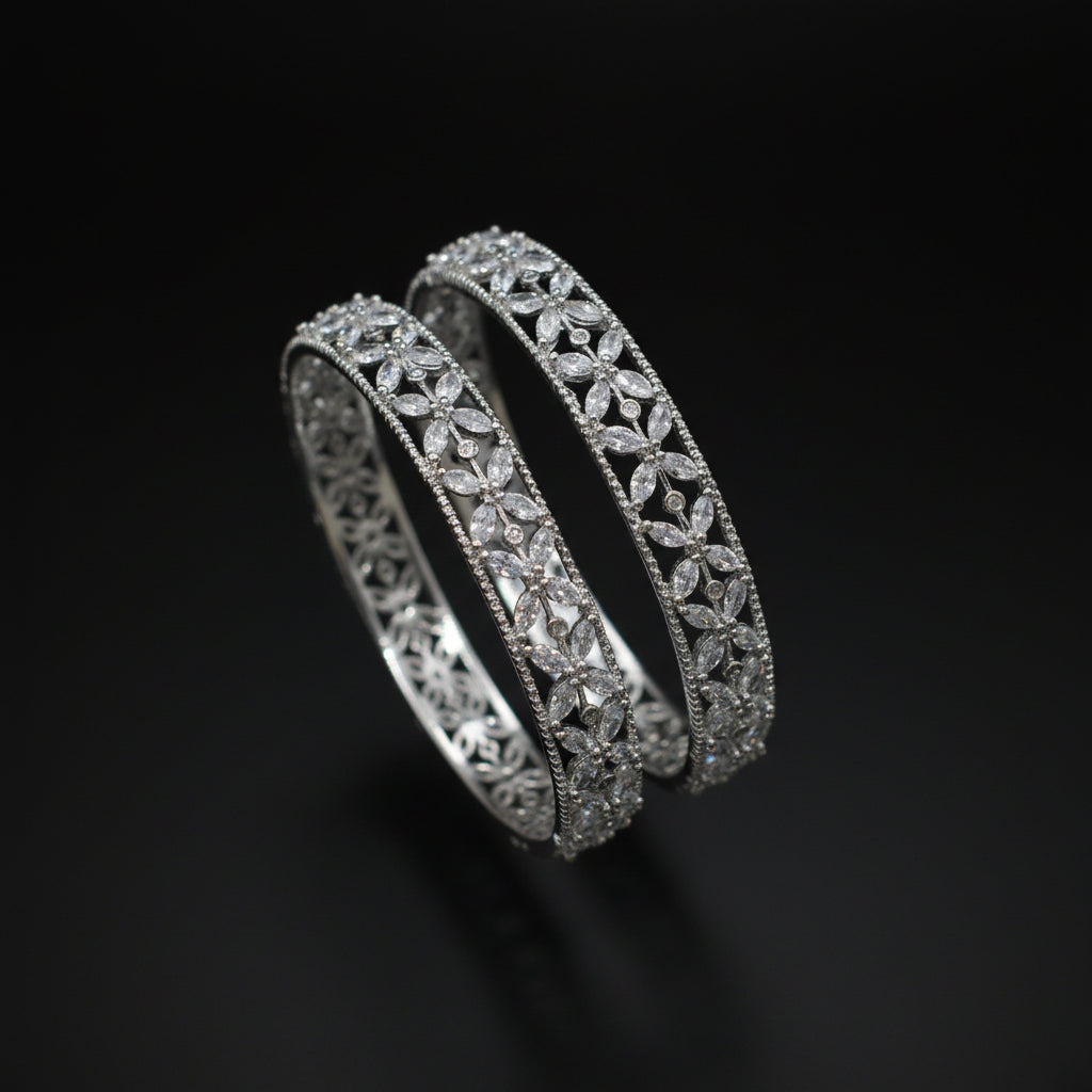 Two diamond bracelets on a gray cushion against a dark background