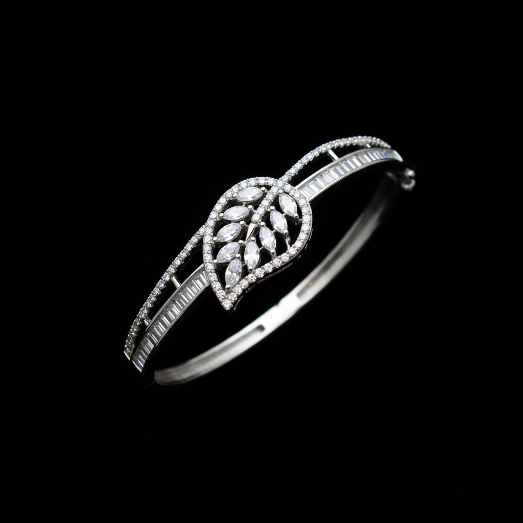 Silver leaf-shaped bracelet on a gray cushion with a dark background