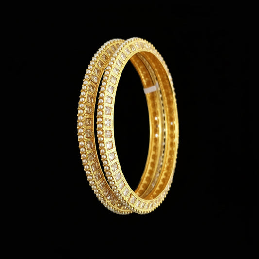 Gold bangles on a black stand with 'SAHELLI' branding.