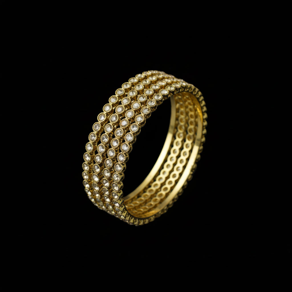 Gold bracelet on a gray stone surface with a dark background
