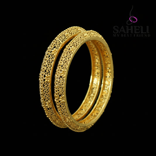 Gold bangles on a dark background with 'Saheli' branding.