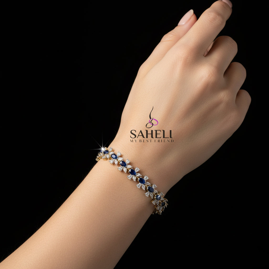 Gold bracelet with blue and white stones on a dark background, featuring the brand 'Saheli'.