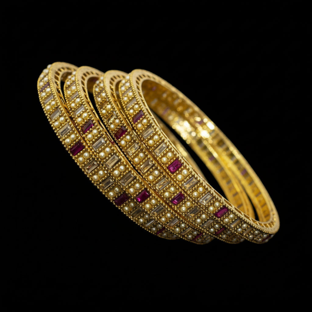 Gold bangles with embedded stones on a reflective surface, featuring the brand 'Saheli'.