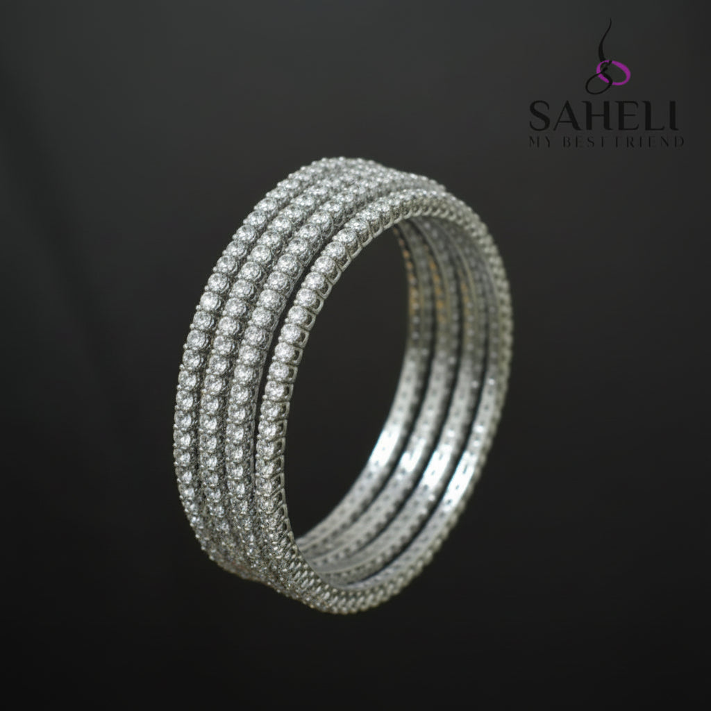 Set of silver bangles on a black stand with 'SAHELI' branding.