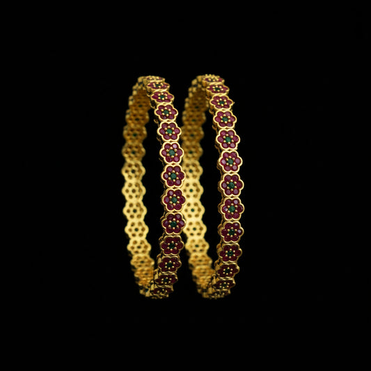 Gold and red floral bangles on a black background with 'Saheli' branding.