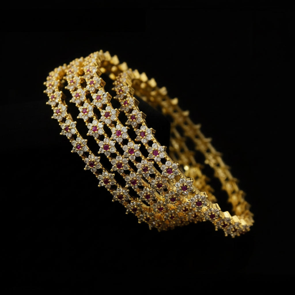 Gold bracelet with red stones on a dark background, featuring the brand 'Sarehli'.