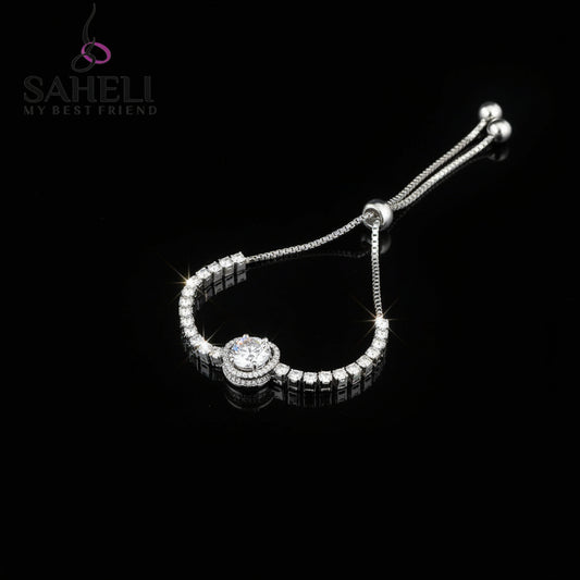Silver bracelet with heart-shaped clasp on a dark background, featuring the brand 'SAHELI'.