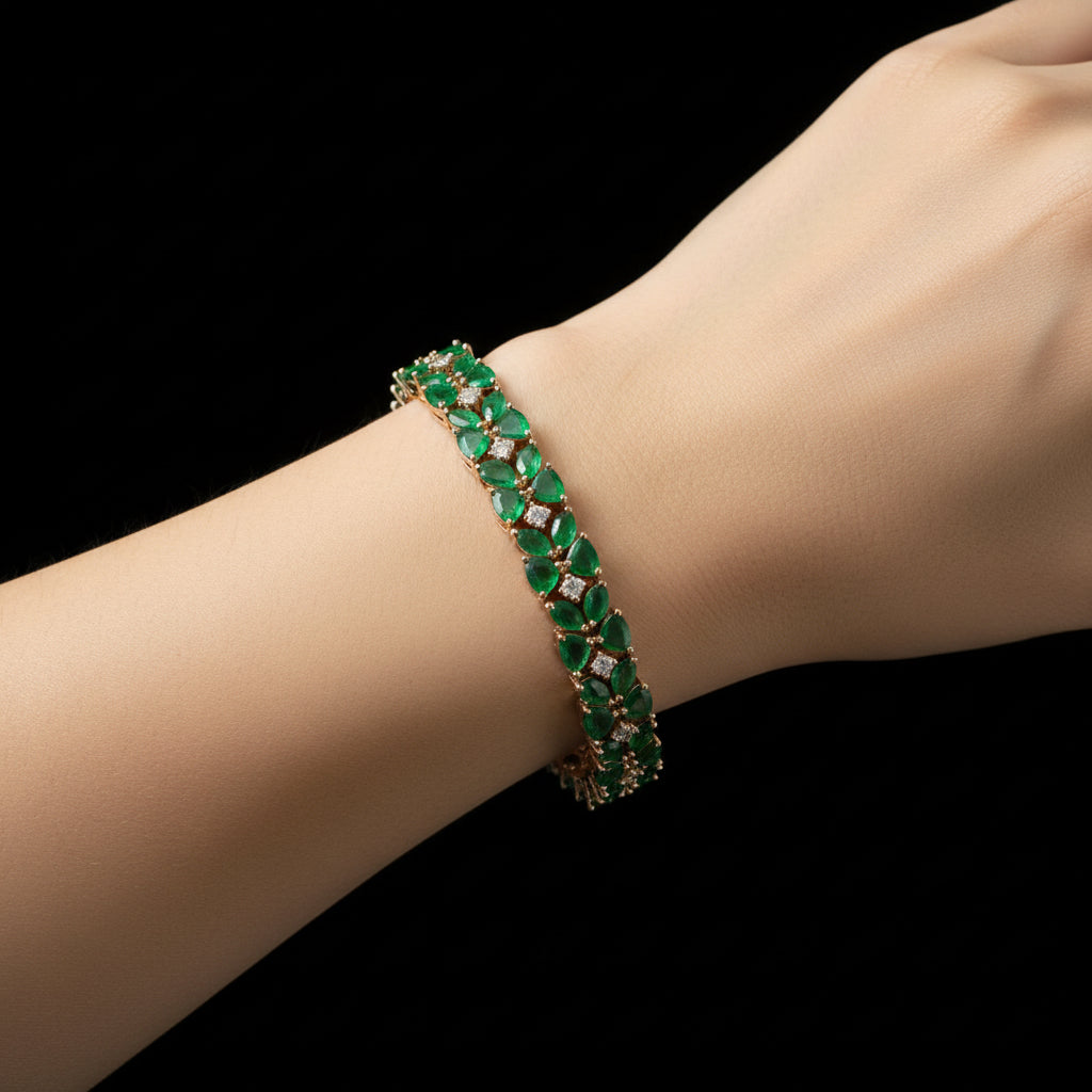 Gold bracelet with green stones on a dark gray background
