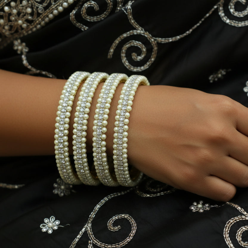Pearl bangles on a black mannequin with 'SAHELI' branding.
