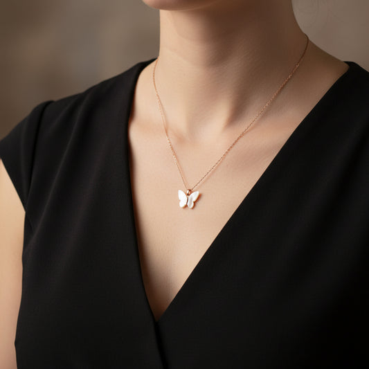 Rose gold butterfly necklace on a branded card against a black background
