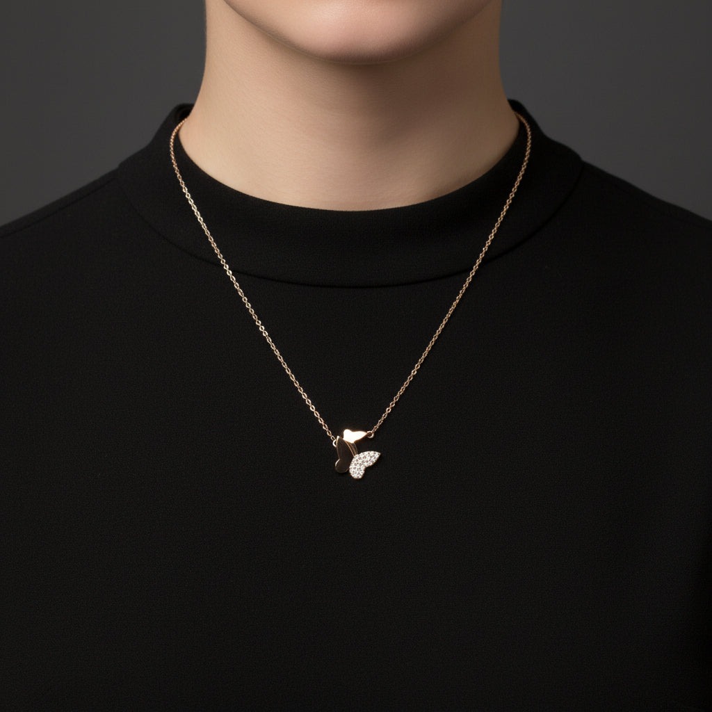Rose gold necklace with a butterfly pendant on a white card with 'A.B.N.' branding against a black background.