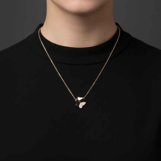 Rose gold necklace with a butterfly pendant on a white card with 'A.B.N.' branding against a black background.