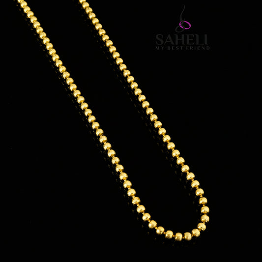 Gold necklace on a gray background with 'SAHELI' branding.
