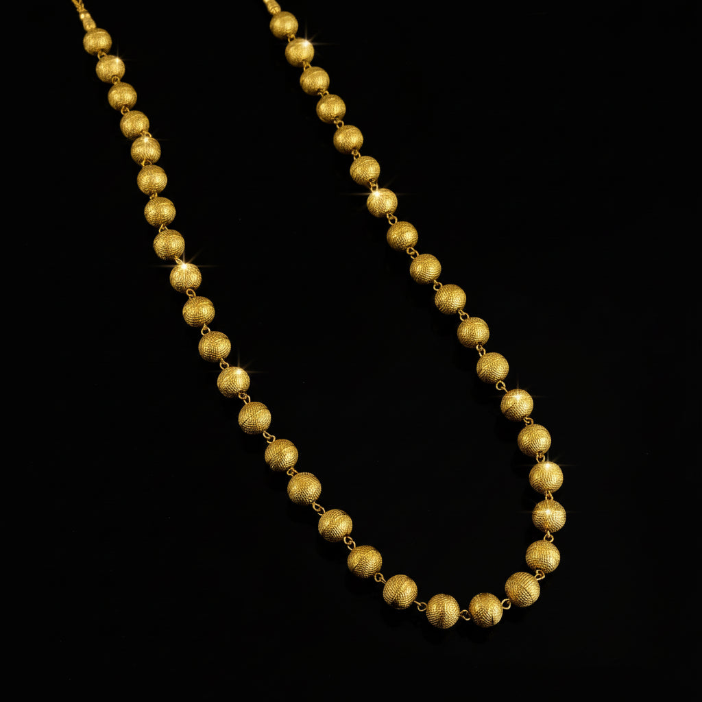 Gold necklace on a reflective surface with 'SAHELI' branding.