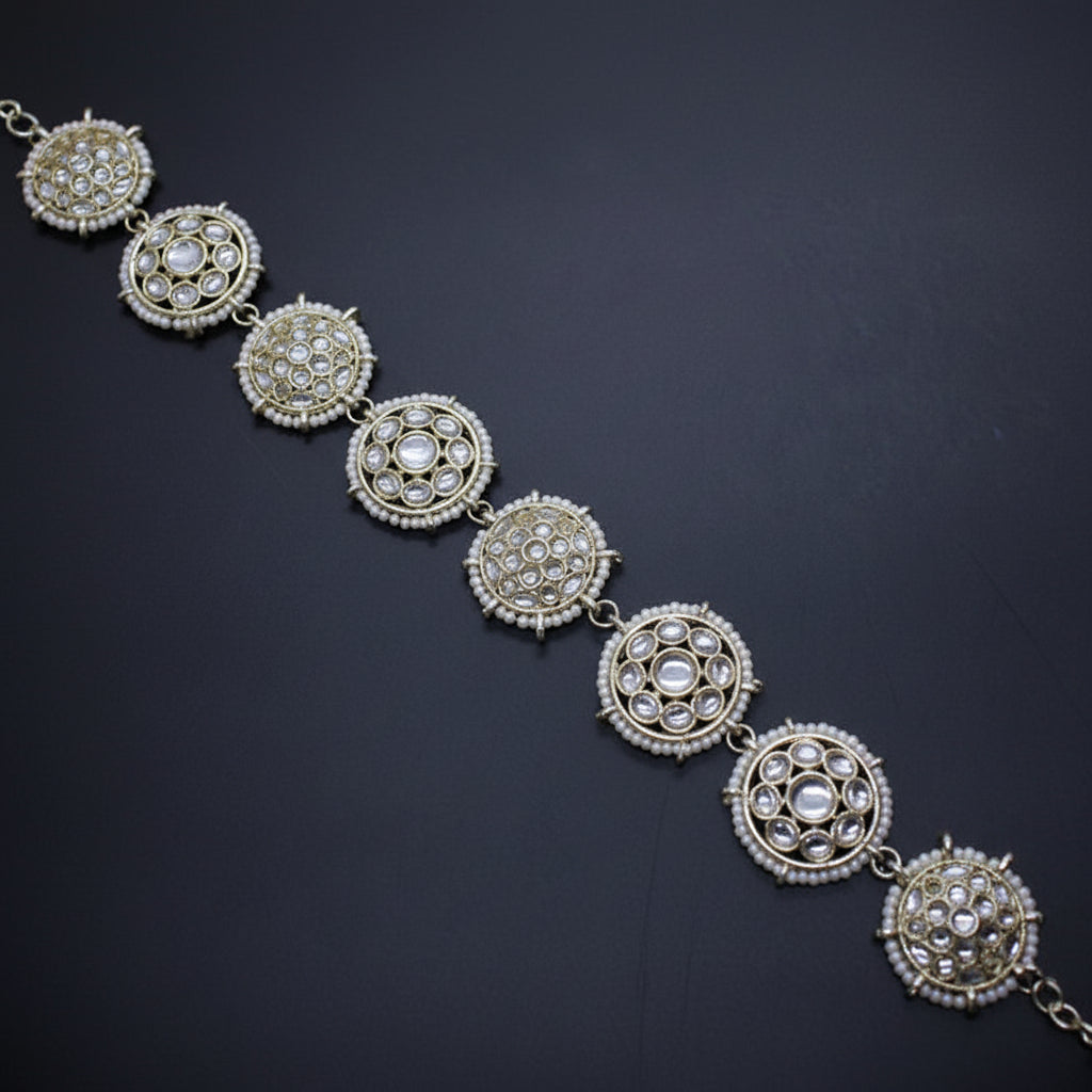 Silver necklace with circular pendants on a dark background, featuring the brand 'Saheli'.