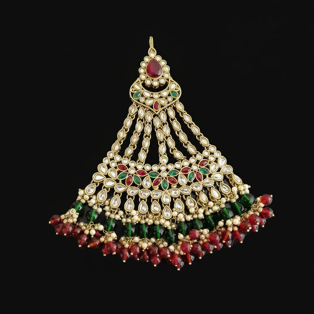 Ornate gold, green, and red jewelry piece with 'SAHELI' branding on a gray background