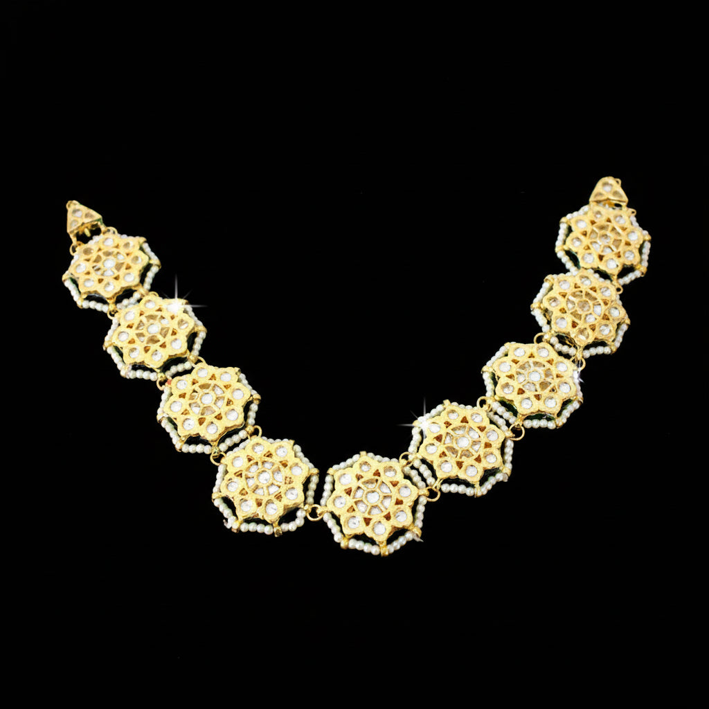 Gold necklace with intricate design on a black background, featuring the brand 'Saheli'.
