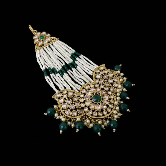 Ornate necklace with green and white beads on a black background