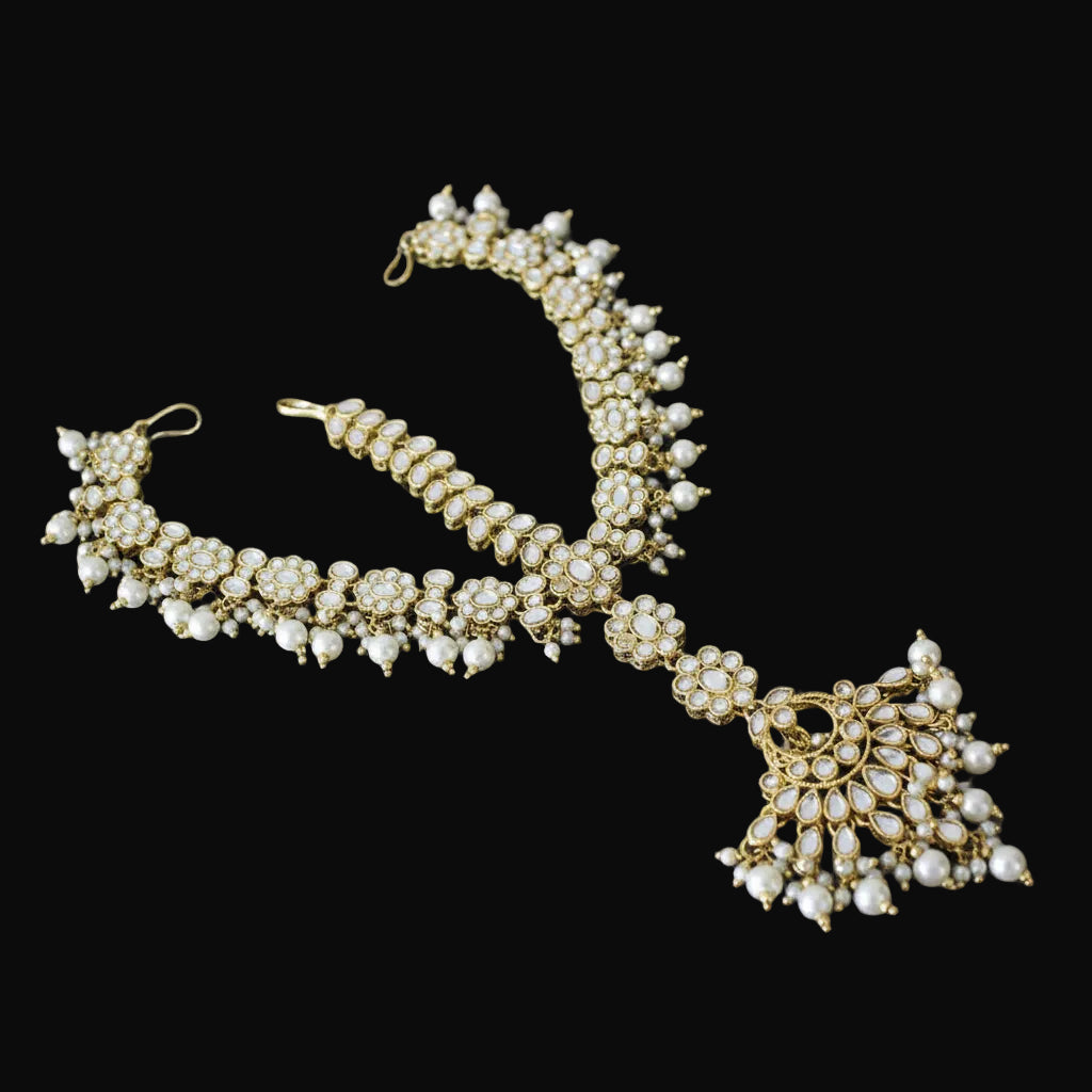 Gold and pearl necklace on a dark background with 'SAHELI' branding.