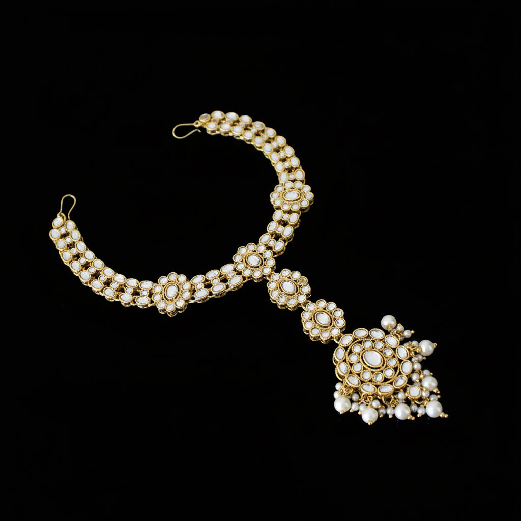 Gold and pearl necklace on a dark background with 'SAHELI' branding.