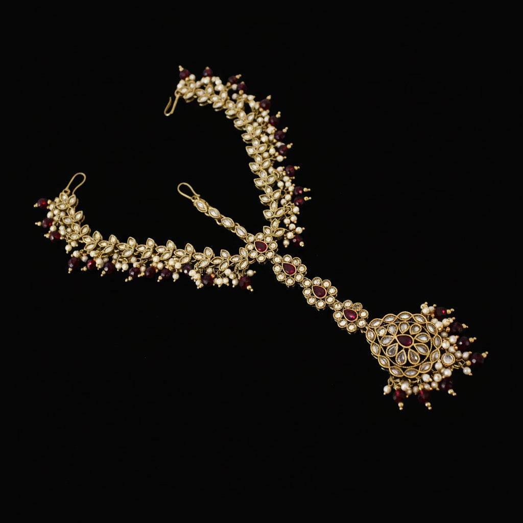 Ornate necklace with red stones on a dark background, branded 'Saheli'.