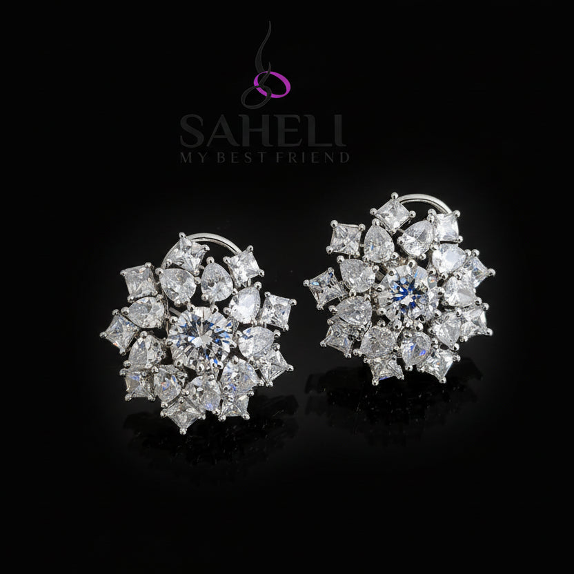 Pair of diamond earrings with 'SAHELI' branding on a dark background