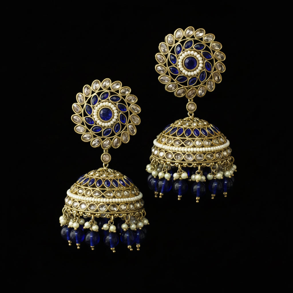Pair of gold and blue earrings on a black stand
