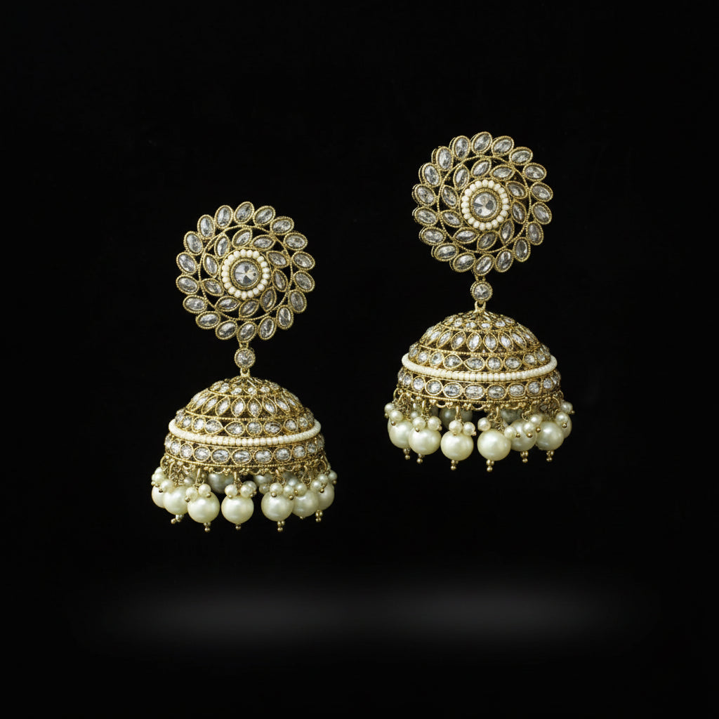 Pair of gold and pearl earrings on a black stand