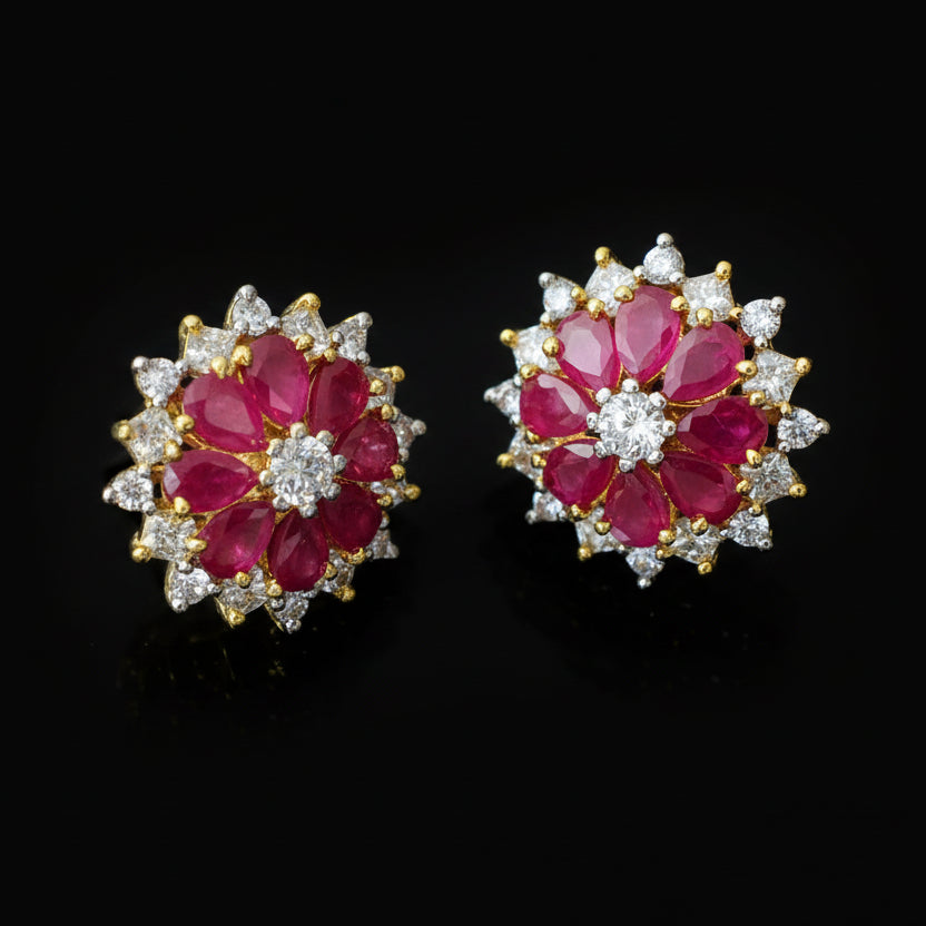Pair of earrings with red gemstones and gold accents on a dark background, branded 'Saheli'.