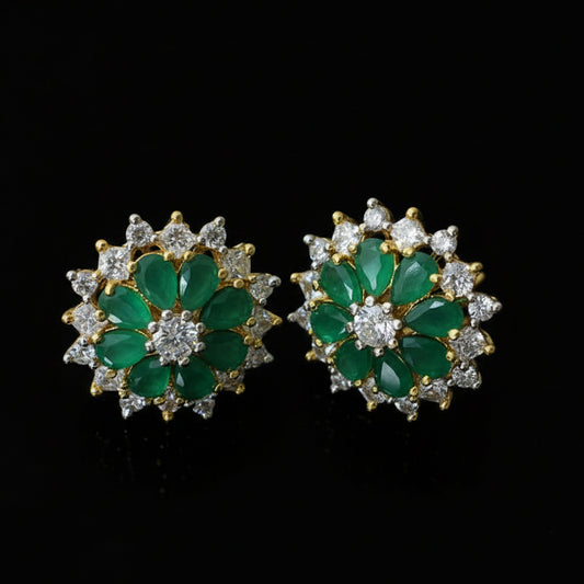 Pair of green gemstone earrings with gold accents on a dark background, branded 'SAHELI'.