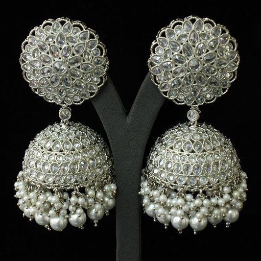 Pair of silver and pearl earrings on a black stand