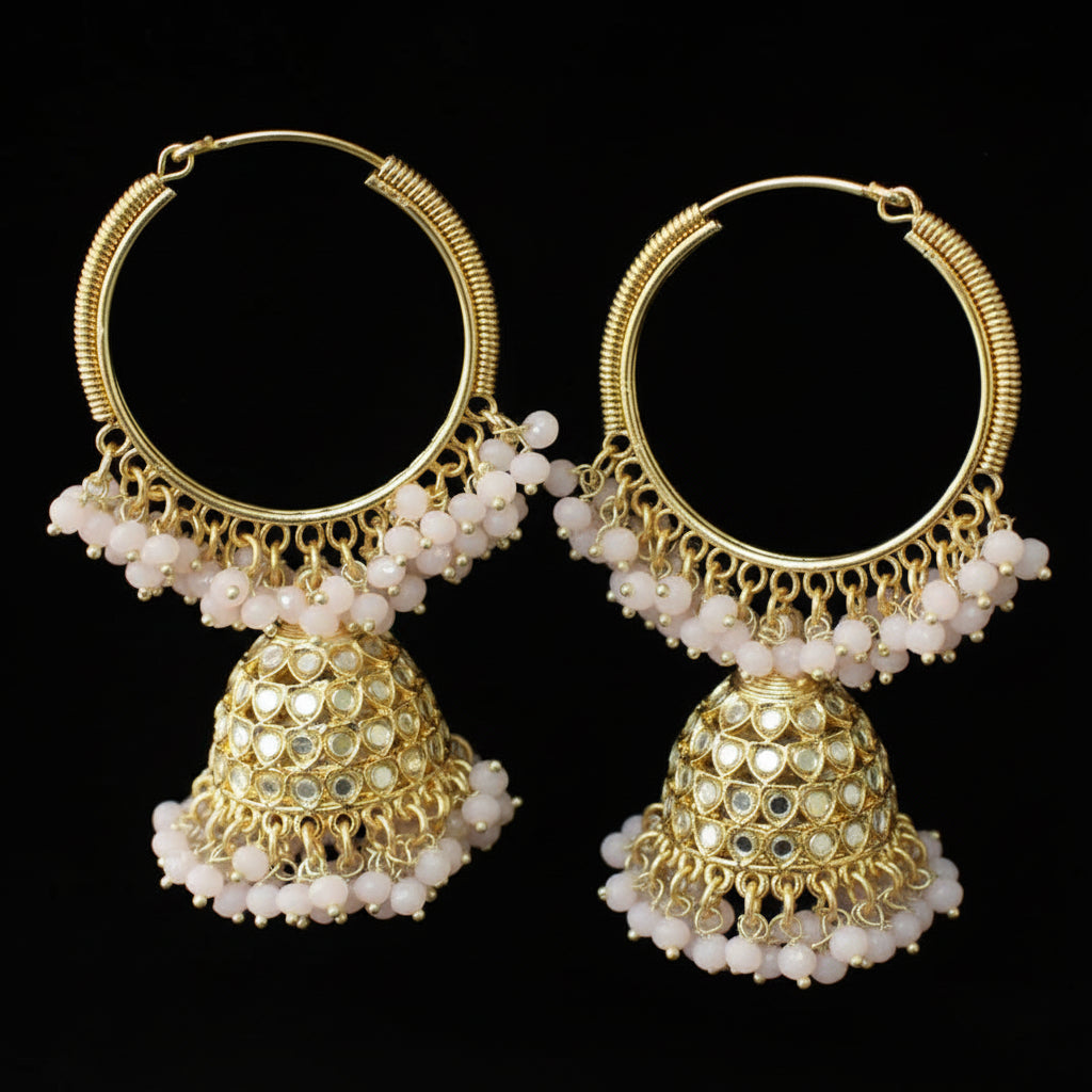Pair of gold hoop earrings with white beads on a black background
