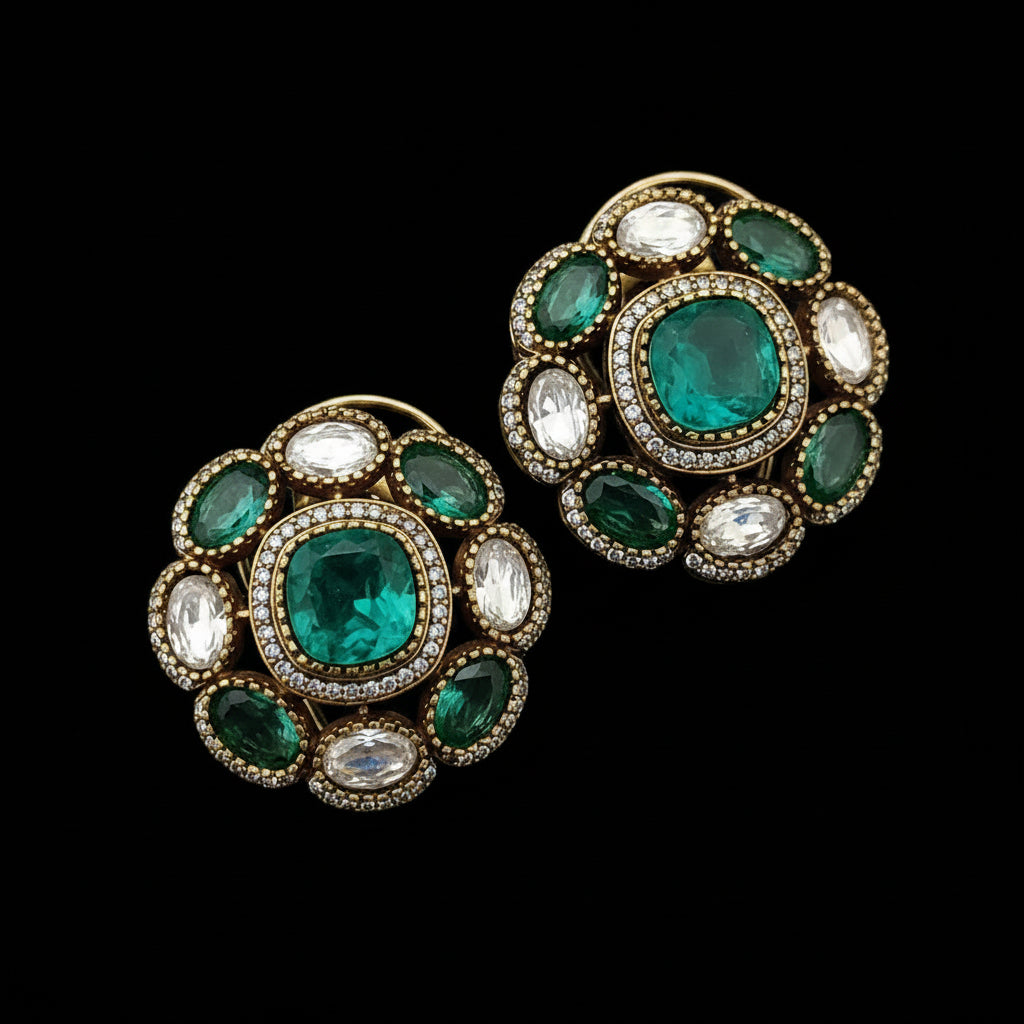 Pair of ornate earrings with green gemstones and 'SJNX-CODE-R-135' text on a light gray background.