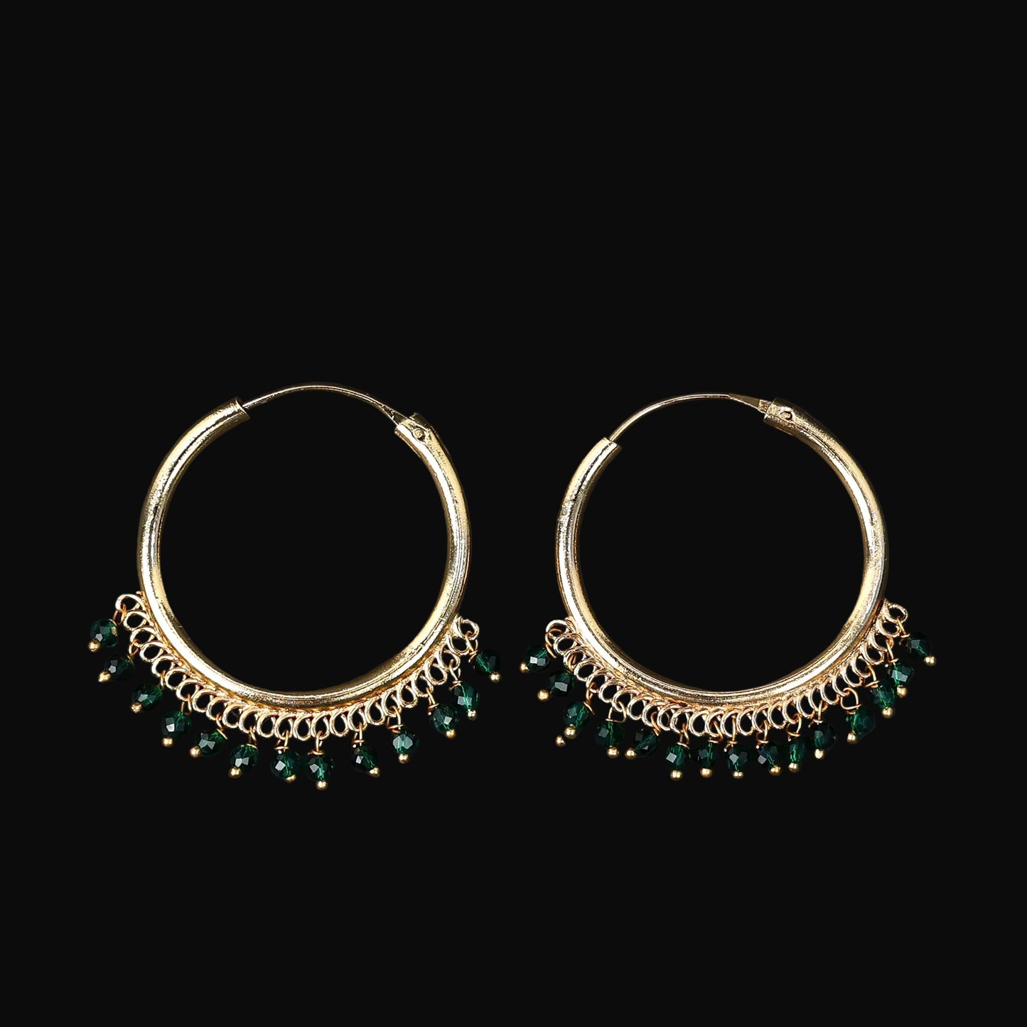 Gold hoop earrings with green beads on a dark background, featuring the Saheli brand.