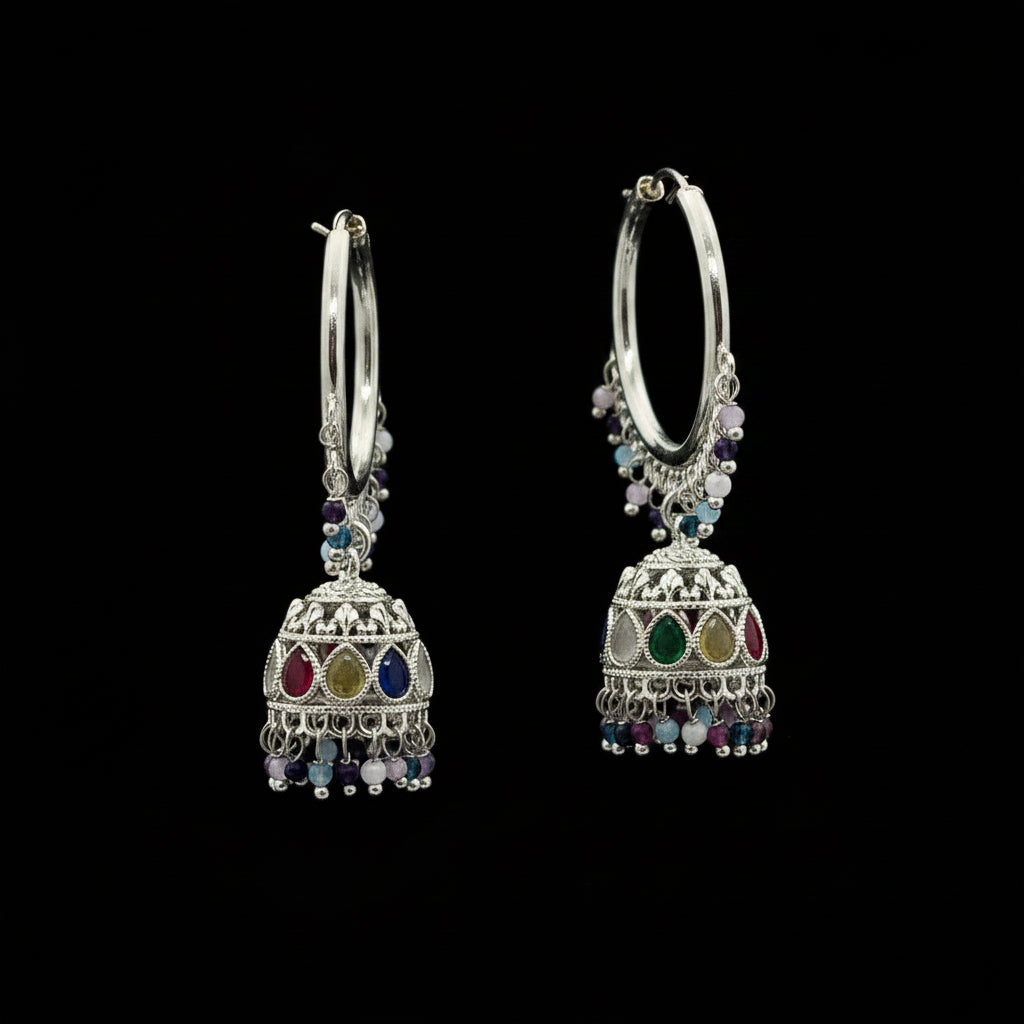 Silver hoop earrings with colorful beads on a purple background