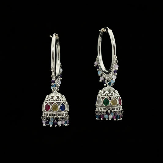 Silver hoop earrings with colorful beads on a purple background