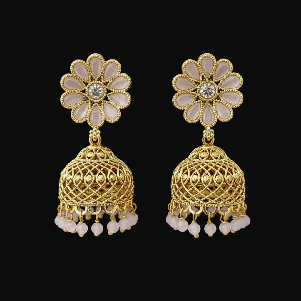 Gold floral earrings with pearl accents on a gray stand against a black background