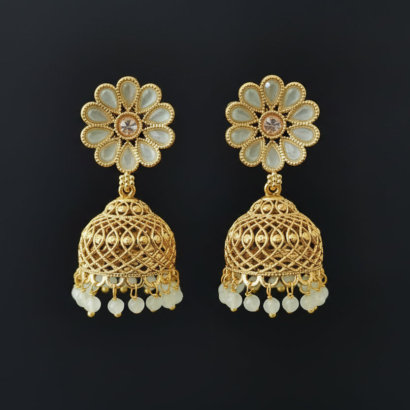 Gold and green floral earrings on a gray stand with a black background