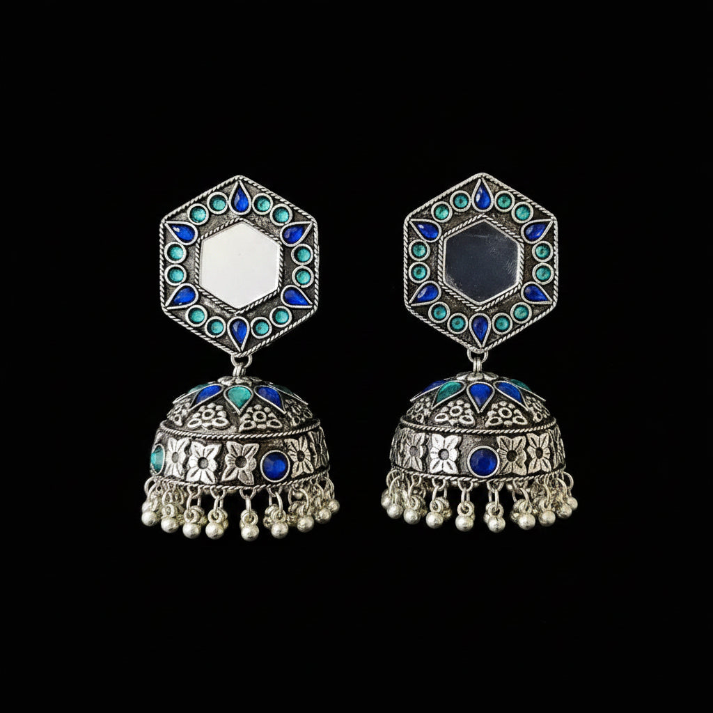 Ornate silver earrings with blue and green gemstones on a black background