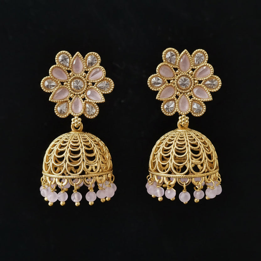 Gold floral earrings with intricate designs on a dark background