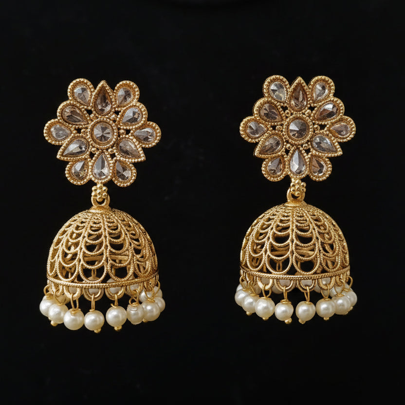 Gold earrings with floral designs and pearl accents on a black background
